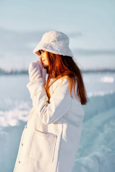 Bonita mujer en un abrigo blanco en un sombrero paseo paisaje de invierno Aire fresco — Foto de Stock