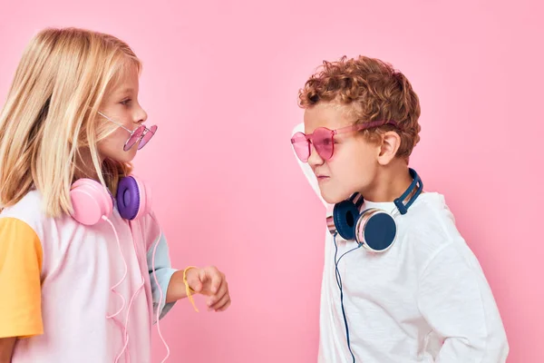 Roztomilý usmívající se děti v slunečních brýlích bavte se s přáteli růžové barvy pozadí — Stock fotografie