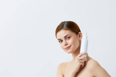 Çıplak omuzlu güzel kadın cilt bakım losyonu Gri arka plan