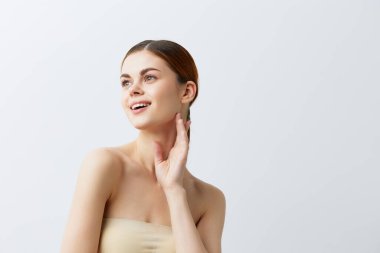 Güzel bir kadın, gülümseyen bir kadın, çıplak omuzlar, temiz bir cilt cazibesi.