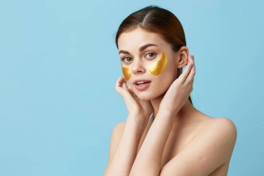 Güzel kadın altın yamalar, temiz ten tebessümü izole edilmiş arka plan.