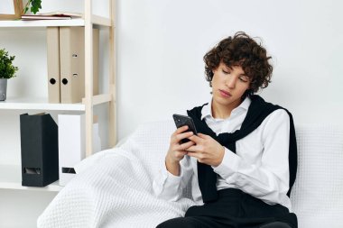 Genç kız kanepede telefonda internetten iletişim kurmayı öğreniyor.