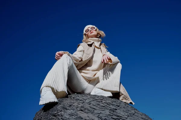 Fiatal nő ül egy kő természet kék ég egy kalap életmód — Stock Fotó