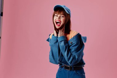 Şapka ve kot ceketli çekici bir kadının portresi. Renk arkaplanı değiştirilmemiş.