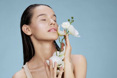 Yüze yakın güzel bir orkide çiçeği. Mavi arka plan.