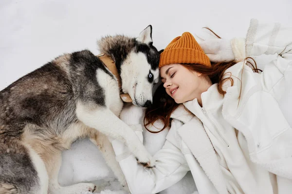 Mulher alegre ao ar livre em um campo no inverno andando com um cão ar fresco — Fotografia de Stock