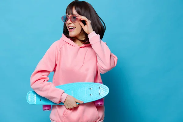 Ung kvinna blå skateboard poserar roligt isolerad bakgrund — Stockfoto