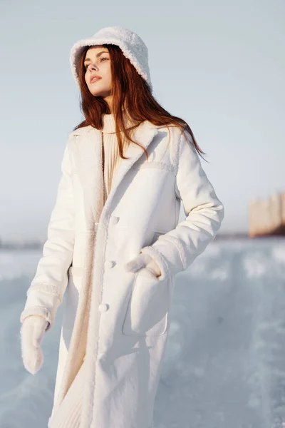 Bela mulher em um casaco branco em um chapéu inverno paisagem passeio natureza — Fotografia de Stock