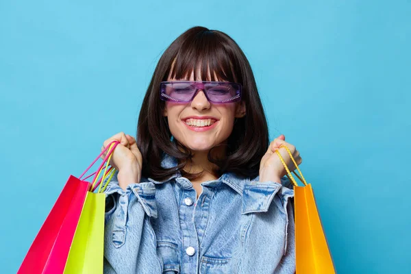 Mulher em óculos de sol compras emoções posando alegria fundo azul — Fotografia de Stock