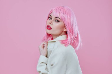 Beyaz ceketli çekici bir kadının portresi. Pembe saçlı. Pembe arkaplan değiştirilmemiş.