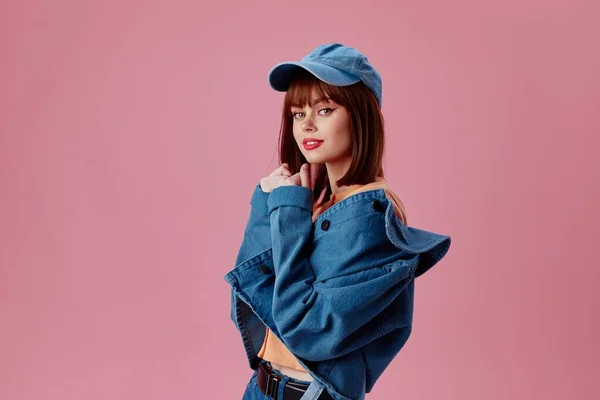 Портрет чарівної леді в шапці і джинсовій куртці, що позує кольоровий фон незмінним — стокове фото