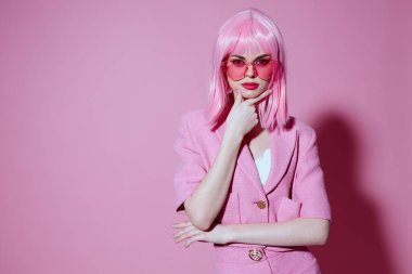 Genç bir kadının portresi, elleri ile pembe ceketli ve değiştirilmemiş bir stüdyo modeliyle jestler yapıyor.