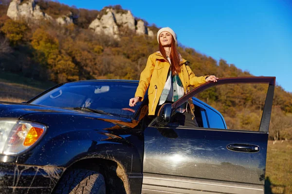 Mujer viajero en una chaqueta amarilla en una mochila sombrero viajes montañas relajación — Foto de Stock