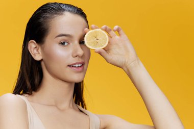 Ellerinde limon yiyen portre kadın gülümseyen vitaminler izole edilmiş arka plan.