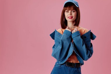 Pozitif genç kadın şık kot giysisi. Renk arka planı değiştirilmemiş.