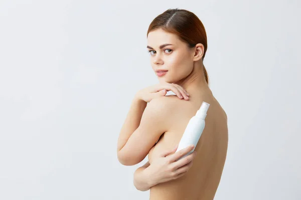 若い女性化粧水瓶きれいな肌の健康管理クローズアップライフスタイル — ストック写真