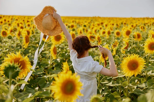 Ritratto di donna in cappello su un campo di girasoli campagna — Foto Stock