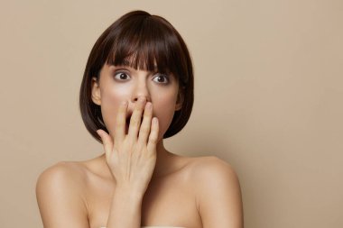 Esmer, çıplak omuzlar. Açık ten. Yakın çekim pozu veriyor.