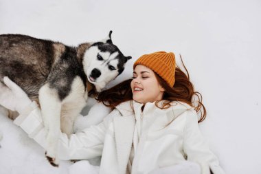 Mutlu genç kadın kış kıyafetleri karda köpeği gezdiriyor taze hava