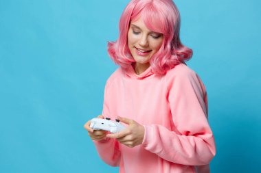 Pembe sweatshirt 'lü genç bir kadın eğlence dünyasının mavi arka planında
