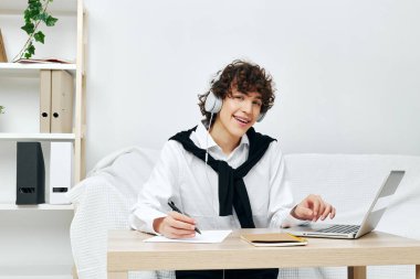 Genç kız, masadaki koltukta dizüstü bilgisayarla iletişim kuruyor.