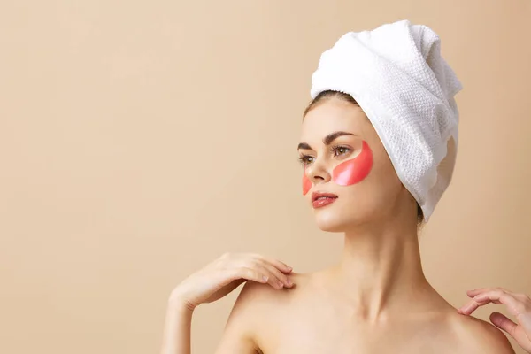Mujer bonita manchas de color rosa en la cara con una toalla en la cabeza fondo aislado — Foto de Stock
