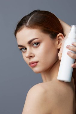 Genç kadın losyonu kavanozu. Temiz cilt bakımı.