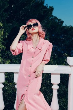 Çekici bir kadın, el kol hareketleriyle eski moda poz veriyor.