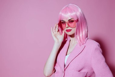 Çekici bir kadının portresi. Elleriyle jest yapıyor. Pembe ceketli.