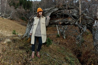 Ağacın yanında duran bir kadının portresi Sonbahar tarzı taze hava Sonbahar yürüyüşü