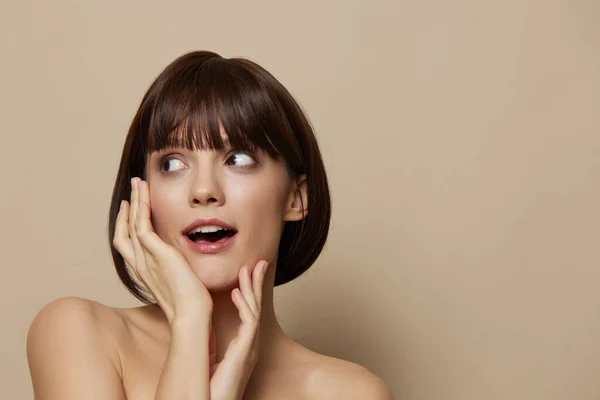 Yüz bakımına yakın genç kadın makyaj bej arka plan — Stok fotoğraf