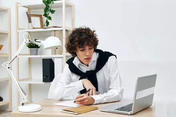 Adolescente sentado no sofá à mesa na frente de uma comunicação laptop — Fotografia de Stock