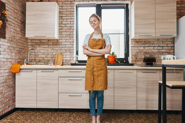 Hermosa mujer en un delantal marrón cocina interior hogar vida — Foto de Stock