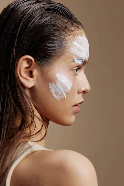 woman applying a soothing face mask cosmetic Youth and Skin Care Concept