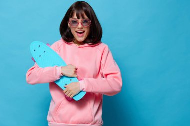 Mavi kaykaylı kadın. Eğlenceli mavi arka plan.