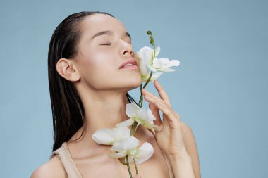 Yüze yakın genç kadın orkidesi kozmetik ürünleri temiz cilt hassasiyeti izole edilmiş arka plan