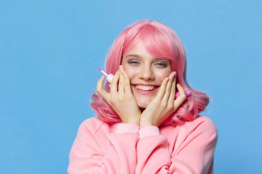 Pembe saçlı kadın makyajı mavi arka planda.