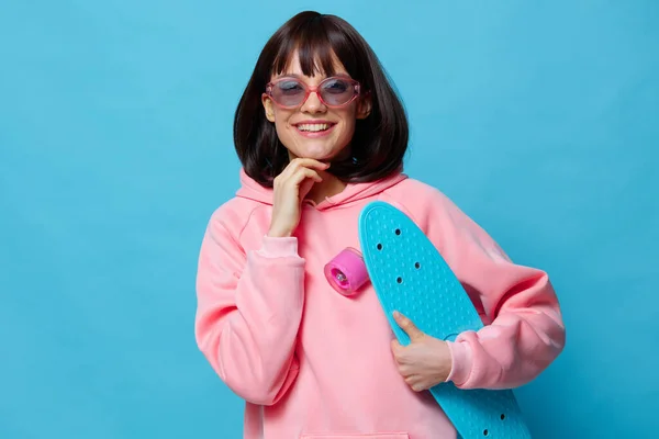 Porträtt kvinna i solglasögon med en skateboard isolerad bakgrund — Stockfoto