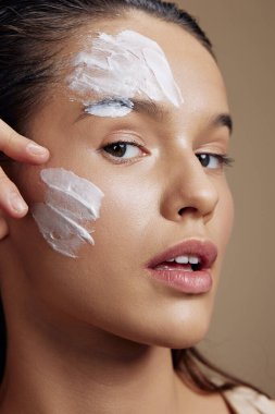 Genç kadın, el kreminin yanında gençleştirme cazibesi izole edilmiş arka plan.