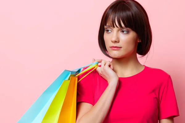 Mujer con coloridas bolsas de compras fondo rosa —  Fotos de Stock