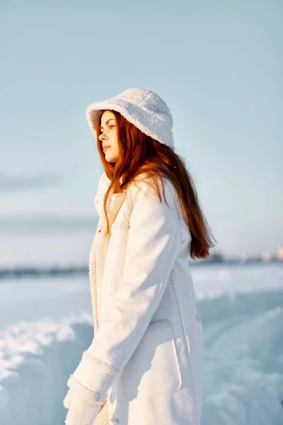 Beyaz önlüklü, kış manzaralı genç bir kadın doğa yürüyüşü yapıyor. — Stok fotoğraf