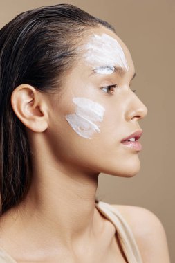 Genç kadın, el kreminin yanında gençleştirme cazibesi izole edilmiş arka plan.