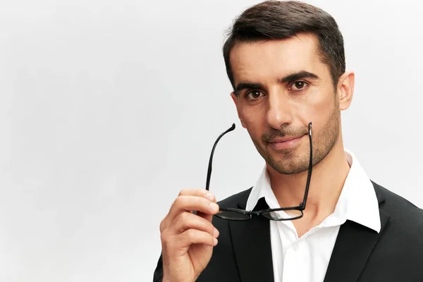 Bell'uomo con gli occhiali in un abito elegante sorriso posa fiducia in se stessi sfondo isolato — Foto Stock