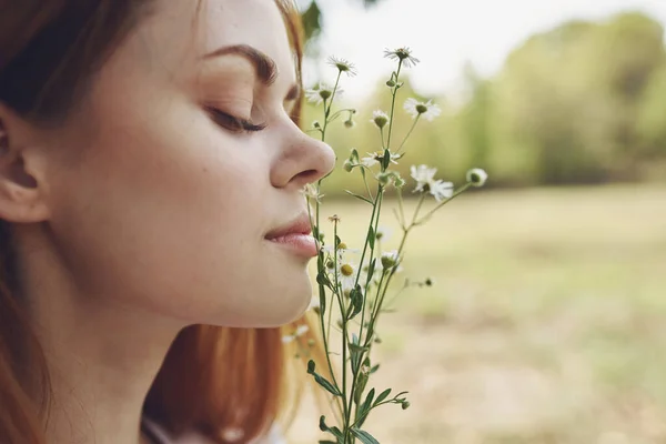 Retrato de una hermosa mujer con flores silvestres y con los ojos cerrados en la naturaleza en un prado —  Fotos de Stock
