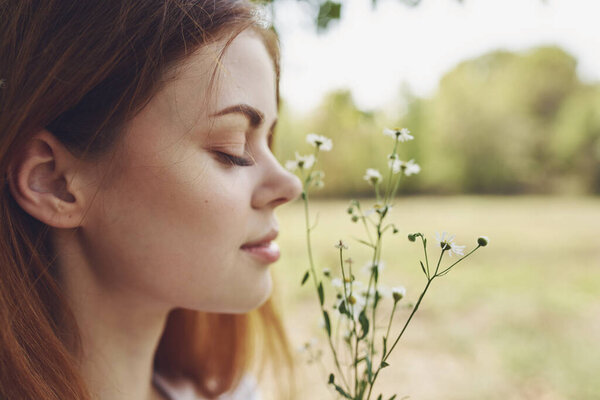 Portrait of a beautiful woman with wildflowers and with closed eyes on nature in a meadow Stock Photo