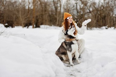 Kış manzarası olan genç bir kadın arkadaşlık yürüyüşü yapıyor.