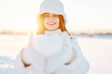 Beyaz önlüklü güzel bir kadın kış manzarası yürüyüşü yapıyor.