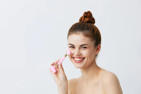 Porträt Frau Jade Gesichtsmassager Falten glätten gebundene Haare in einem Dutt Nahaufnahme Lifestyle — Stockfoto
