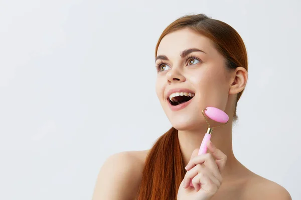Pretty woman pink quartz roller skin care massage bare shoulders close-up Lifestyle — Stock Photo, Image