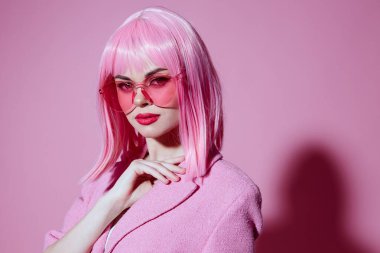 Çekici bir kadının portresi. Elleriyle jest yapıyor. Pembe ceketli.
